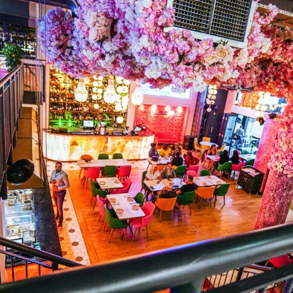 Best Turkish Mediterranean restaurant in the Theatre District Milton Keynes birds eye view of the restaurant, people dining and hundreds of pink flowers hanging from the ceiling